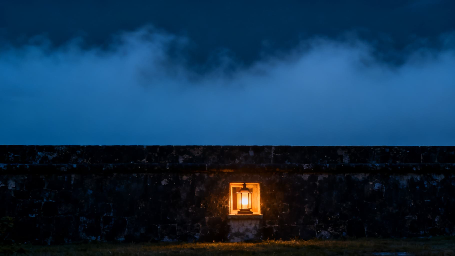 A single lamp burning in a dark wall at night — Philippians 4:6-7
